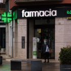 Imatge d'una dona sortint d'una farmàcia a Tortosa.