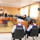 La sala de vistas de la Audiencia de Tarragona, con tres agentes de los Mossos en primer término, con el acusado sentado, de espaldas, a la derecha.
