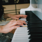 Imagen de archivo de una mujer tocando un piano.