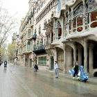 Uns turistes es fotografien davant la Casa Batlló amb mascareta durant el primer dia laborable de l'estat d'alarma pel coronavirus.
