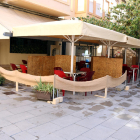 La terraza de un bar del centro de Tortosa con mamparas|biombos de madera que separan las mesas|tablas