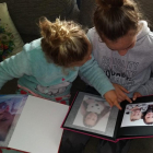 La Claudia i la Rocío mirant fotos de quan eren petites.