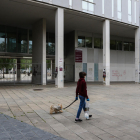 Una persona pasea un perro ante el acceso al interior del Campus Catalunya cerrado.