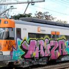 Cabecera del vagón de un tren de Rodalies lleno de pintadas.
