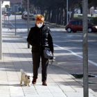 Una señora con mascarilla paseando a su perro por la avenida del Canal de Mollerussa donde se tendría que estar celebrando la Feria de Sant Josep, suspendida por el coronavirus