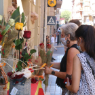 Dos joves comprant roses a la Floristeria Tost de Tortosa durant el Sant Jordi d'estiu.
