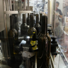 Unas botellas de vino en una maquina en la Bodega Mas Vicenç.