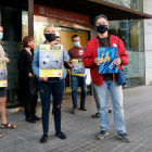 Marta Minguella, delegada de CGT Enseñanza, y Xavier Massó, secretario general de Profesores de Secundària, muestran un cartel con la convocatoria de huelga.