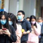 Ciudadanos de Guangzhou haciendo cola para comprar mascarillas.