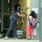 Una nena desinfectant-se les mans amb gel hidroalcohòlic a la porta de l'escola.