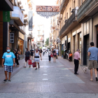 Pla general de diverses persones amb bosses de compra al carrer Monterols de Reus.