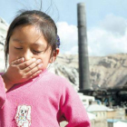 Imagen de un niño al lado de una instalación industrial.