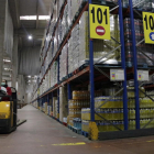 Trabajadores con mascarilla preparando pedidos para supermercados y tiendas en la plataforma logística de GM Food
