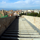 Un tram del pas de ronda de la muralla de Tarragona, a la zona de la Baixada del Roser, amb el paviment inacabat i les vistes de la ciutat al fons