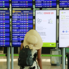 Una viatgera consultant les pantalles informatives a l'Aeroport del Prat el 31 de juliol de 2020.