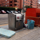 Un contenidor soterrat de Tarragona amb diversos voluminosos a la vora, com ara un matalàs i un bressol mig desmuntat.