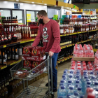 Un hombre comprando alcohol en un supermercado.