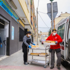 Dos miembros de Cruz Roja recogen alimentos para llevarlos al pabellón del Serrallo.