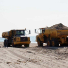 Dos camiones aportando arena en la playa de Calafell.