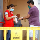 Una sanitaria poniendo hielo|gel a un usuario antes de un cribado por coronavirus en Manlleu.