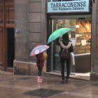 Una dona i una nena, a punt d'entrar en una pastisseria del carrer Comte de Rius de Tarragona.
