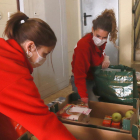 Des tècniques de Creu Roja Tarragona posant el menjar en bosses de plàstic des del replà de casa del beneficiari, pero no entrar-hi com a mesura preventiva per la covid-19.