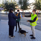 Dos agentes cívicos informando a una mujer con su perro.