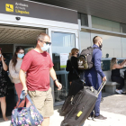 Plano general de turistas con maletas, en la terminal de llegadas del aeropuerto de Reus.
