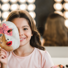 Imagen de una niña con una máscara.