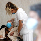 Imagen de archivo de una enfermera atendiendo a una persona mayor.
