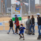 Un grup de persones passegen pel passeig marítim de la platja de Sant Lorenzo de Gijón