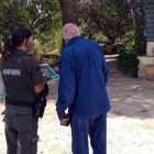 Una Agente Rural informante un propietario del Perelló sobre los perímetros de autoprotección en caso de incendio forestal.