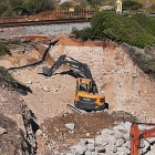 Una excavadora trabaja para reparar un boquete en el tramo Vilanova-Sitges de la línea de Rodalies de Renfe R2 sur.