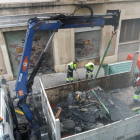 Operarios de limpieza retirando los contenedores quemados en la calle de la Selva del Camp.