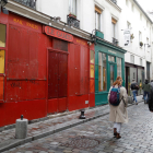 Diverses persones caminen davant d'un bar tancat per les restriccions de la covid-19 a París.