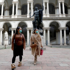 Dos turistas con mascarillas mientras visitan el claustro del Palazzo di Brera de Milán, donde ya se han confirmado diversos infectados.