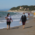 Dues dones amb mascareta caminant per la platja d'Altafulla en el primer dia permès per sortir a practicar esport.