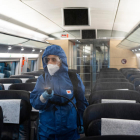 Plano abierto de un operario de una empresa de servicios desinfectando el interior de un tren de Renfe.