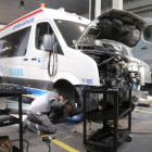 Pla mitjà d'un mecànic en un taller que només repara vehicles de serveis essencials