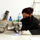 Una de las trabajadoras de la Tapicería Nilcar confeccionando mascarillas