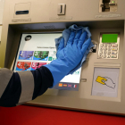 Un treballador de TMB neteja una màquina de venda de bitllets.