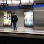Un home amb mascareta esperant el metro a l'andana de l'estació de Diagonal de Barcelona.