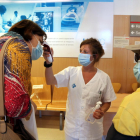Pla mitjà d'una infermera prenent la temperatura a dos pacients abans que entrin a consultes externes de l'Hospital Verge de la Cinta de Tortosa.