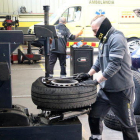 Un mecànic repara un pneumàtic, en un taller del polígon Riu Clar de Tarragona.