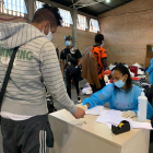Una voluntària de Càritas atenen temporers al pavelló 3 de Fira de Lleida