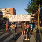 Dues persones sostenen una pancarta reivindicativa i, al fons, part de la gent que es va manifestar.