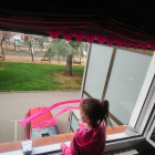 Una niña en la ventana de su casa en Ripoll.