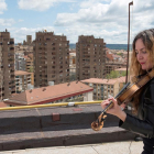 Daniela tocando el violín en el terrado.