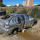 Alguns turismes que semblen abandonats s'aguanten sobre pedres i estan coberts de pintades