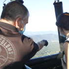 El pilot assenyala un punt del paisatge a una passatgera del vol aerostàtic a la Garrotxa